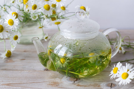 Herbal tea of chamomile in tea pot on wooden tableの写真素材