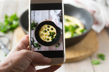 Taking a photo of scrambled eggs with Brussels sprouts with smart phone, healthy food conceptの写真素材