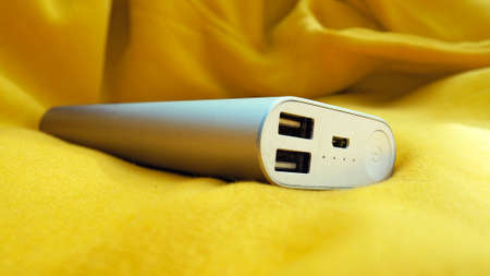 Power Bank with two usb on yellow fabric background.の写真素材
