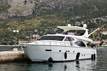 big white luxury yacht moored near pier