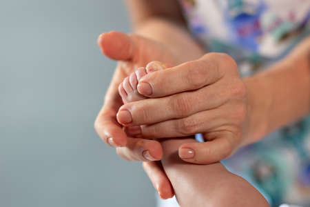 woman hands massaging baby legの写真素材