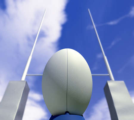 A plain white rugby ball on a kicking tee in front of some rugby posts ready to be convertedの写真素材