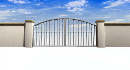 A solid garden wall with closed metal gates with a blue sky in the background and isolated on a...