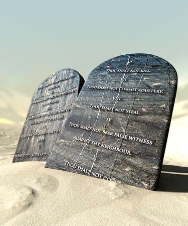 Two stone tablets with the ten commandments inscribed on them standing in brown desert sand infront of a blue skyの写真素材