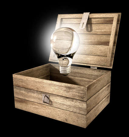 An open rough wooden planked box with a hinged lid and a hasp with a regular illuminated lightbulb above it on an isolated backgroundの写真素材