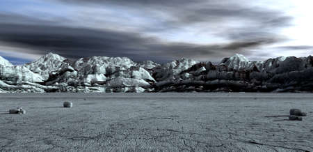 An ominous landscape with a barren flat foreground and mountains in the background under a stormy skyの写真素材