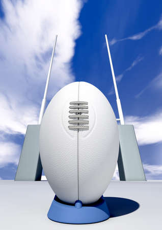 A front view of a plain white rugby ball on a blue kicking tee in front of some rugby posts on a blue sky backgroundの写真素材