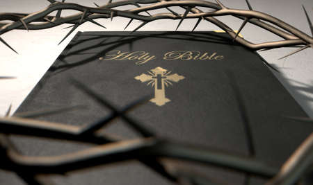 A black leather bible with a gold inscription with a crown of thorns on top of it on an isolated backgroundの写真素材