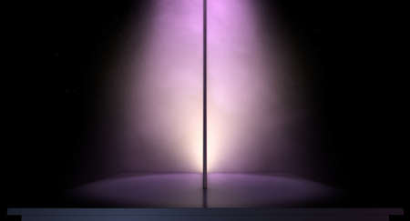 An isolated stripper pole on a stage lit by a single pink spotlight on a dark backgroundの写真素材