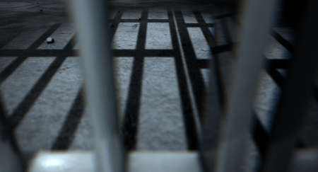 A closeup of view of a jail cells iron bars casting shadows on the prison floor with copy space