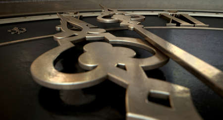 An extreme closeup of a section of an antique clock with roman numerals and ornate metal hands on an...