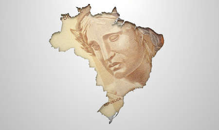 The shape of the country of Brazil in the colours of its national real currency recessed into an isolated white surfaceの写真素材