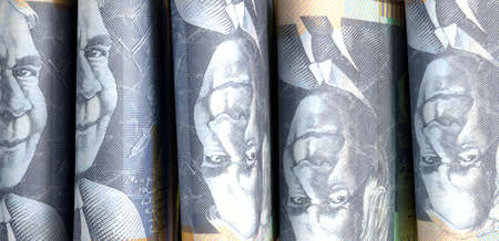 A close-up view of five wads of folded over stacks of australian dollar banknotes each bound...