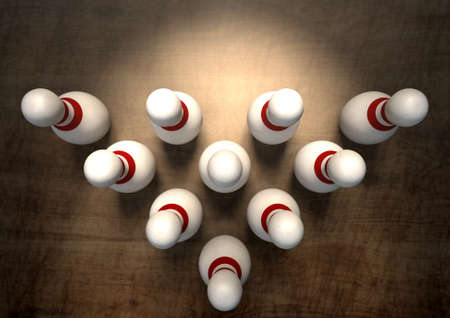 An arrangement of white and red used vintage bowling pins resting on a wooden bowling alley surface on a dark backgroundの写真素材