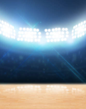 An indoor gynasium with an unmarked wooden floor under illuminated floodlightsの写真素材