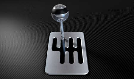 A steel chrome and carbon fibre gear stick shift with an exposed plate on a carbon fibre surfaceの写真素材