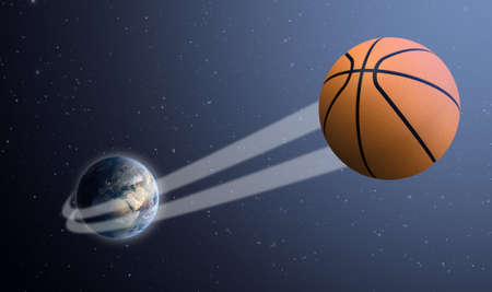 A sporting concept showing a regular basketball ball swooshing out and above the earth onto a starry space backgroundの写真素材