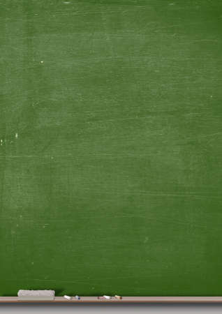 A rectangular green chalkboard with a metal frame with a wooden ledge chalk and a dusterの写真素材