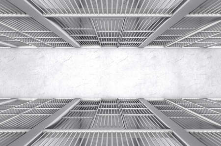 A direct top view of a row of closed jail cells between a concrete aisle lit by a single dramatic spotlightの写真素材