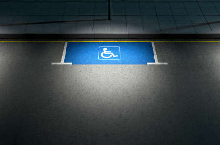 A section of a tarmac road with an empty demarcated paraplegic parking area at night lit by a street...