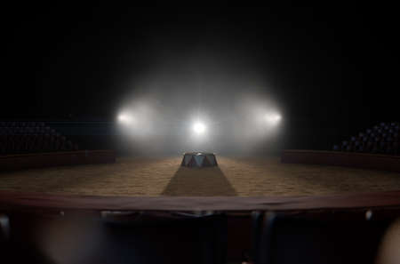 A 3D render of a classic circus arena and an empty ringmasters podium backlit by dramatic spot lights on a dark moody backgroundの写真素材