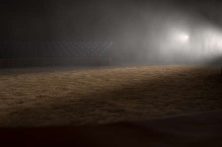A 3D render of an empty classic circus arena backlit by dramatic spot lights on a dark moody backgroundの写真素材