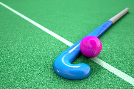 A 3D rendering of a hockey stick and ball on green artificial grass in the daytimeの写真素材
