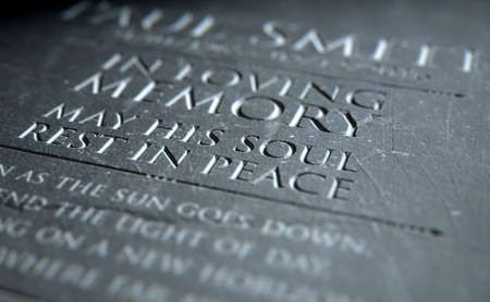 A 3D render of closeup of a carved and etched tombstone highlighting the word in loving memoryの写真素材