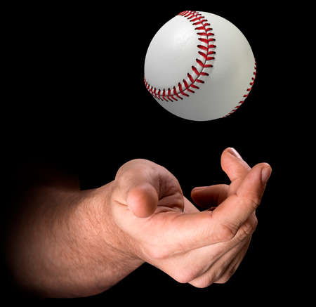A male hand tossing a baseball up in the air on an isolated dark background - 3D renderの写真素材