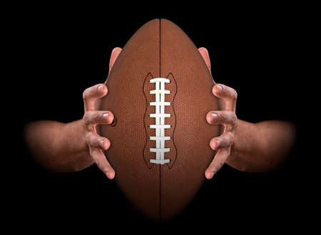 A pair of male hands clamping a football on an isolated dark background - 3D renderの写真素材
