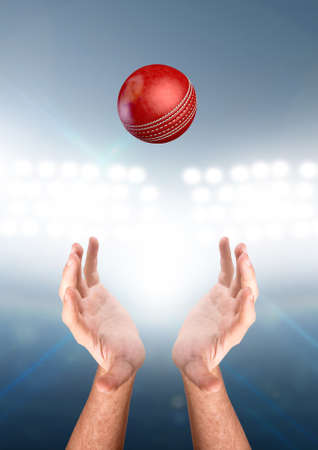A pair of male hands reaching upwards to catch a cricket ball on a floodlit stadium background - 3D...