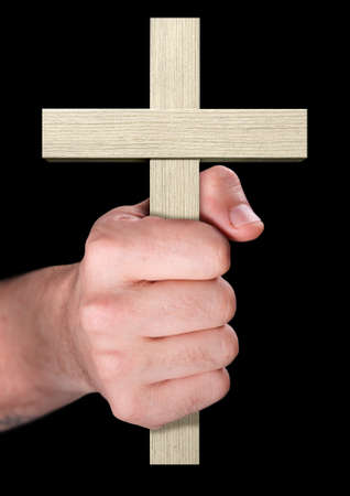 A male hand holding a wooden cross on an isolated black backgroundの写真素材