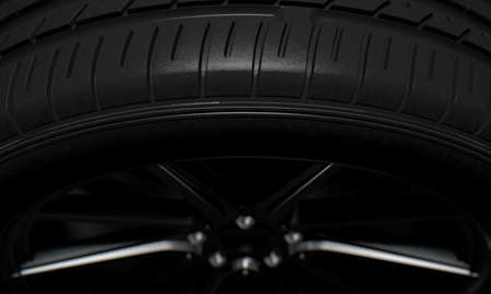 A modern sporty low profile tire on a dark moody studio background - 3D render