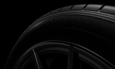 A modern sporty low profile tire on a dark moody studio background - 3D renderの写真素材