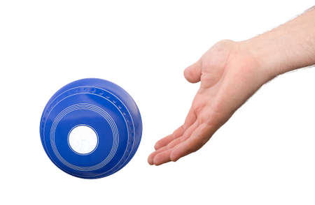 A male hand bowling and releasing a blue wooden lawn bowling ball on an isolated white  surface -3D...