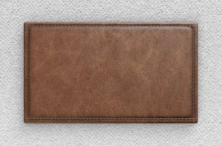 A close up view of a section of white canvas fabric with a blank tan leather label stitched onto it - 3D renderの写真素材
