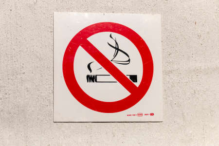 A close up view of a no smoking sign on a white wallの写真素材