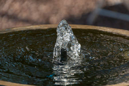 Clear water being pushed out of the top of a concrete water fountainの写真素材