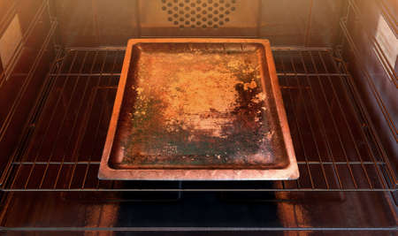 A close view inside a hot operational household oven with an empty tarnished baking tray - 3D renderの写真素材