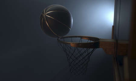 An action shot of a black and gold basketball teetering on the rim of a regular basketball hoop...