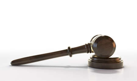 A regular wooden auctioneers hammer or judges gavel with brass trim on an isolated white studio...