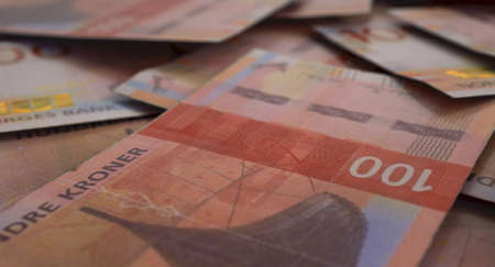 A close-up view of a scattered pile of norwegian kroner banknotes - 3D render