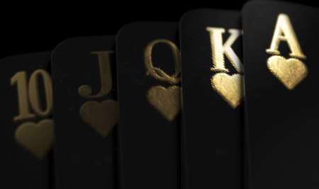 A fanned out royal flush suit of five black casino playing cards with gold markings on a dark classy...