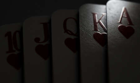 A close up of fanned out royal flush suit of five casino playing cards on a dimly lit background - 3D renderの写真素材