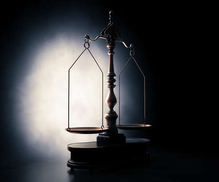 Ornate brass justice scales with a wooden base backlit on a dark moody background - 3D render