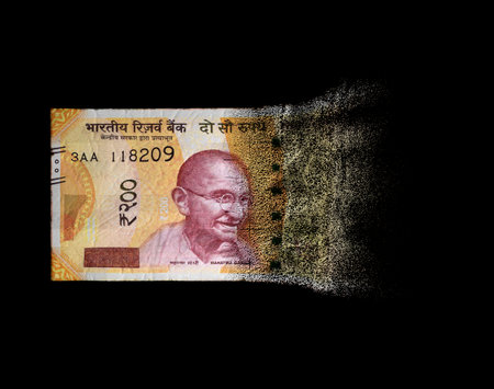 A concept image showing a half dissolved flat paper inia rupee bank note on a dark studio background - 3D renderの写真素材
