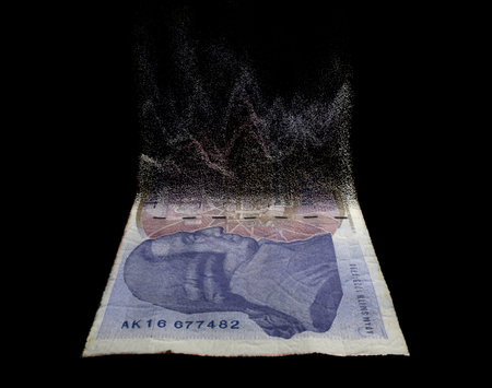 A concept image showing a half dissolved flat paper UK pound bank note on a dark studio background -...