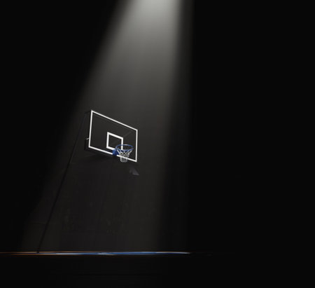 A concept showing a regular basketball hoop dramatically spotlit from above on a dark basketball court background - 3D renderの写真素材