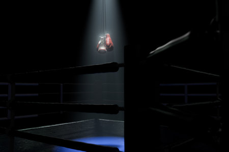 A  boxing ring with spotlit gloves hanging above the centre on an isolated dark background - 3D renderの写真素材