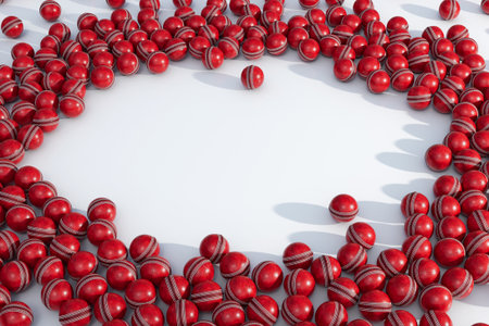 A large array of randomly spaced red, generic cricket sports balls create a clear circular area in...